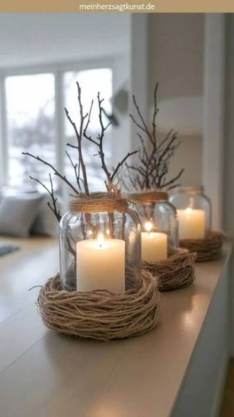 three mason jars filled with candles sitting on top of a table