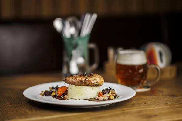a white plate topped with food next to a glass of beer