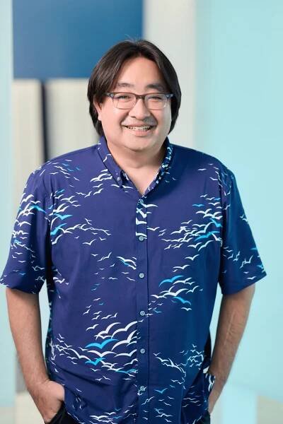 Ying Chen, Tax Division Leader of N&K CPA accounting firm, standing in front of a white and blue background wearing a dark blue blouse and glasses.