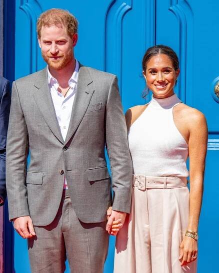 Prince Harry and Meghan holding hands at event