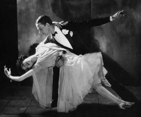 a man and woman are dancing on the dancefloss in an old black and white photo