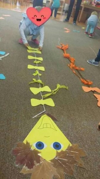 children are playing with paper cutouts on the floor