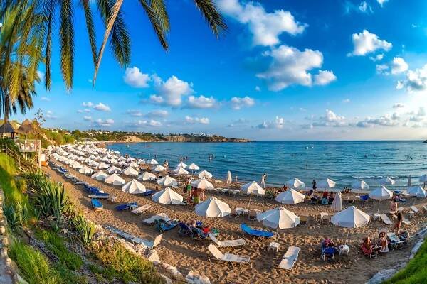 a beach with lots of white umbrellas and chairs