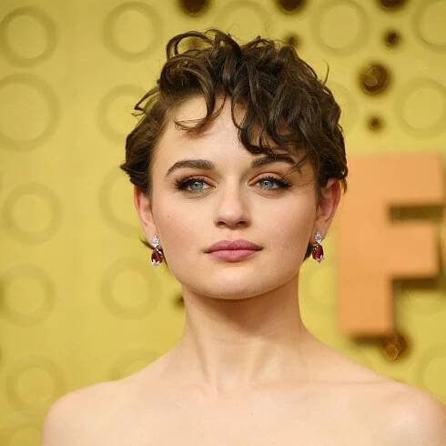 Joey King wearing a short, side-parted haircut with curly side-swept bangs at the 2019 Emmy Awards in Los Angeles