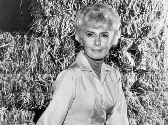Photo of Barbara Stanwyck as Victoria Barkley in shirt and gloves
