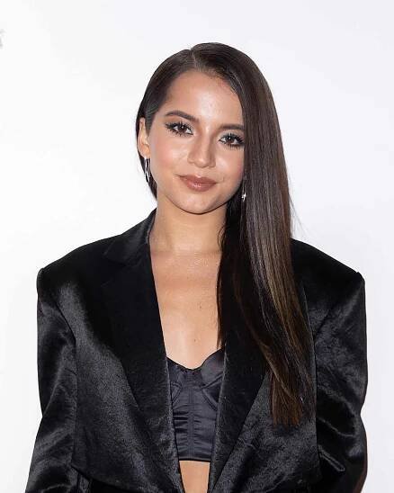 Isabela Merced with a deep side part and long, straight, shiny hair