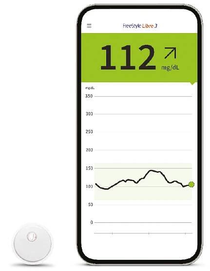 Smartphone mit Anzeige des Glukosewerts. Links daneben der FreeStyle Libre 3 Plus Sensor.