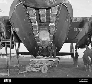 AVRO LANCASTER BOMB LOAD    IWM caption : The bomb load most commonly used for area bombing raids (Bomber Command executive codeword 'Usual') in the bomb bay of an Avro Lancaster of No. 57 Squadron RAF at Scampton Lincolnshire. 'Usual' consisted of a 4,000 impact-fused HC bomb ('cookie'), and 12 Small Bomb Containers (SBCs) each loaded with incendiaries, in this case, 236 x 4-lb incendiary sticks. Stock Photo