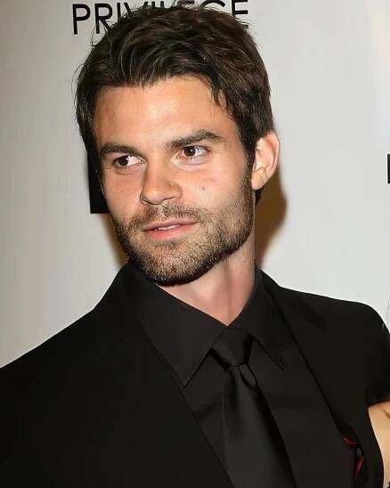 a man wearing a black suit and tie