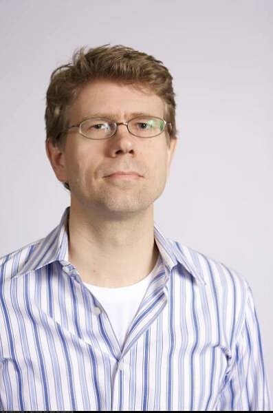 Smiling man in striped shirt and glasses