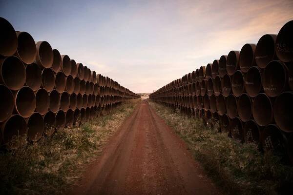 A dirt path with pipe pieces stacked on either side.