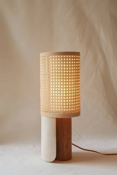 Modern table lamp with a patterned shade emitting warm light, on a wooden base against a cream backdrop.