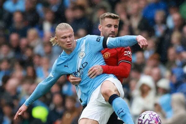 Manchester United defender Luke Shaw tries to get to grips with Manchester City's Erling Haaland. Photo: Reuters
