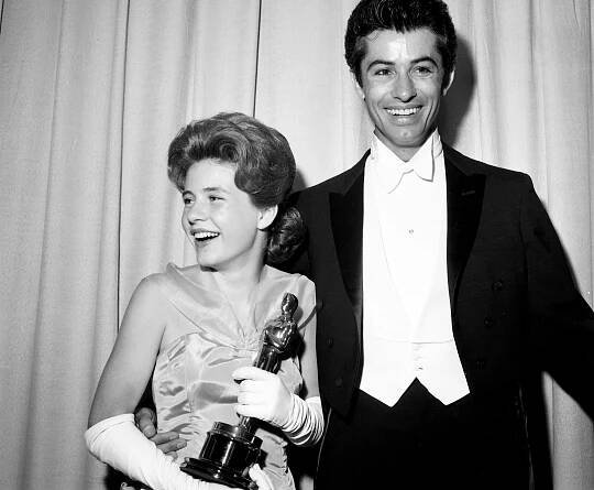 This image may contain George Chakiris Human Person Clothing Apparel Coat Overcoat Suit and Tuxedo