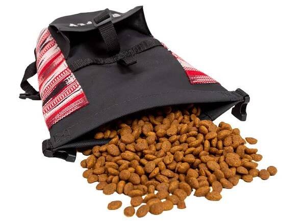 Dog food travel bag laid on its side with kibble spilled out
