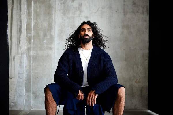 Amar wears ribbed wool cardigan by CONNOLLY. T shirt by ALL SAINTS. Shorts by CRAIG GREEN.