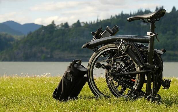 The Brompton P Line is folded in a meadow.