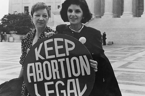 Image of Norma McCorvey (Jane Roe) and her lawyer Gloria Allred on the steps of the Supreme Court, 1989 via Wikimedia Commons
