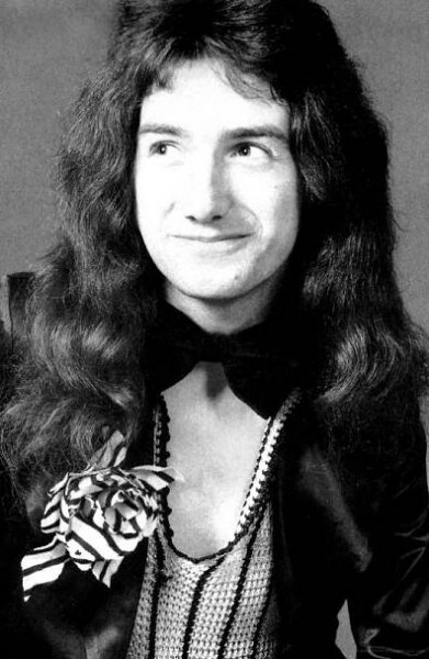 an old black and white photo of a man with long hair wearing a bow tie