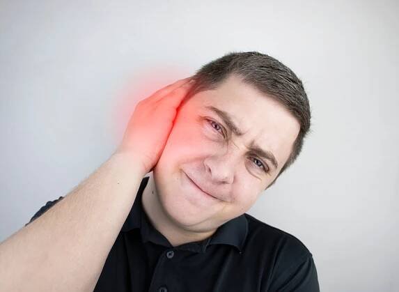 muž trpí bolestí v uchu. sluchový meatus bolí v důsledku zánětu středního ucha, cerumenové zátky, varu ucha nebo trigeminální neuralgie - ušní maz - stock snímky, obrázky a fotky