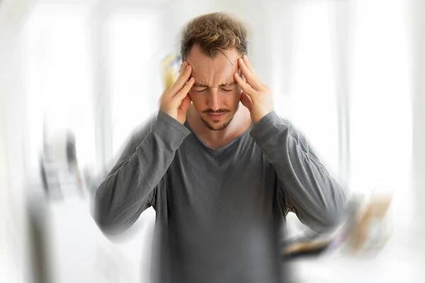 Man experiencing severe headache and vertigo.