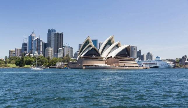 Central business district of city of Sydney with the Pacific Pearl Cruise ship docked in the harbor. View includes the Opera House,  and a broad view of the water in the harbour