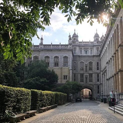 a cobblestone street leading to a large building