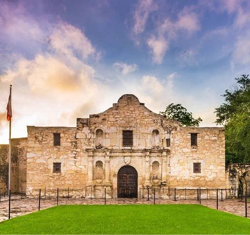 A large stone building with a flag in front of it.