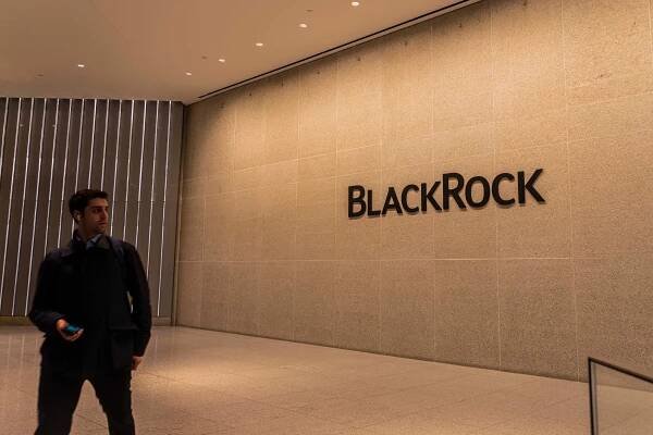The name BlackRock on a wall. A man walks nearby. 