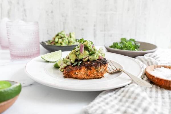 A side image of a blackened mahi mahi filet with guacamole.