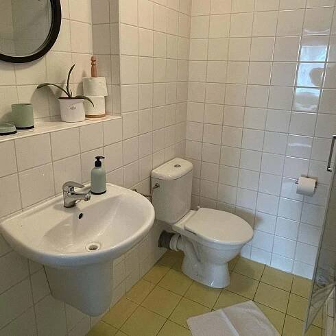 a white bathroom with a toilet and a sink at Penzion Slunečnice in Dvůr Králové nad Labem