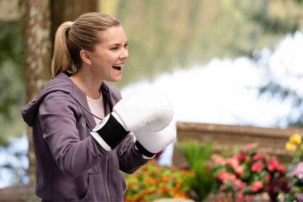 Cindy Busby in a pair of white boxing gloves with her hands up ready to box