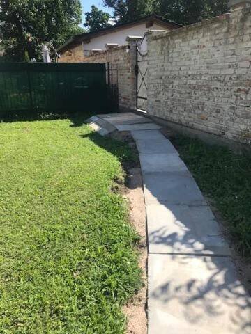 a sidewalk in a yard next to a brick wall at Apartman Romantica in Poděbrady