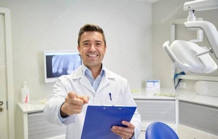 Happy zubař směřující k vám na zubní klinice — Stock Fotografie © Syda_Productions #76031691