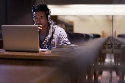 Student working on laptop in library - Bez autorských poplatků Studující - Sociální role Stock fotka