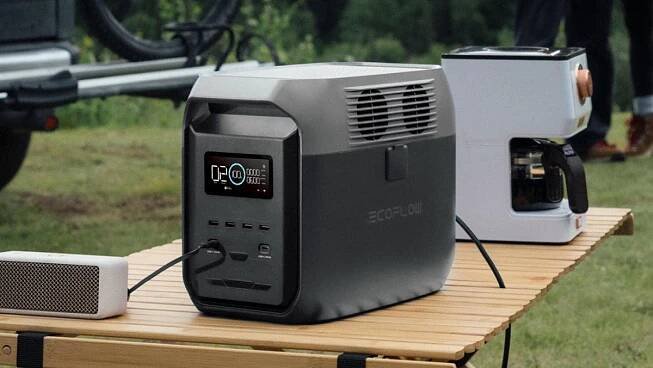 EcoFlow DELTA 3 1500 power station sitting on table outdoors next to speaker and coffee maker