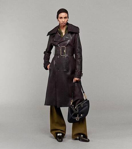 Model wearing Patchwork Leather Trench with Tailored Trousers, holding Leather Medium Shield Twin Bag