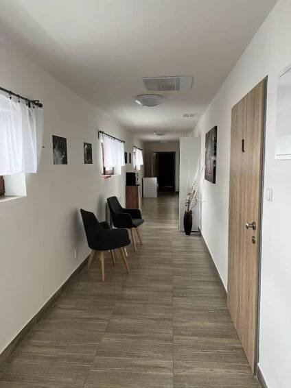 a hallway with chairs and white walls and a hallway with a table at Apartmány Nová duha Vavřinec in Vavřinec