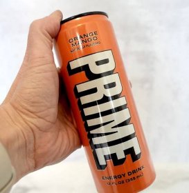 Hand holding PRIME Energy drink in orange