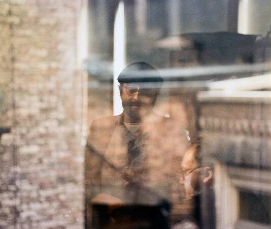 Lucio Dalla through a blurry window shot by Luigi Ghirri