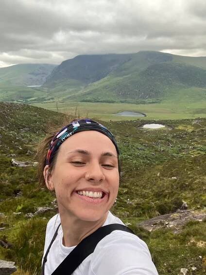Kay in a selfie with cliffs and a valley in the background