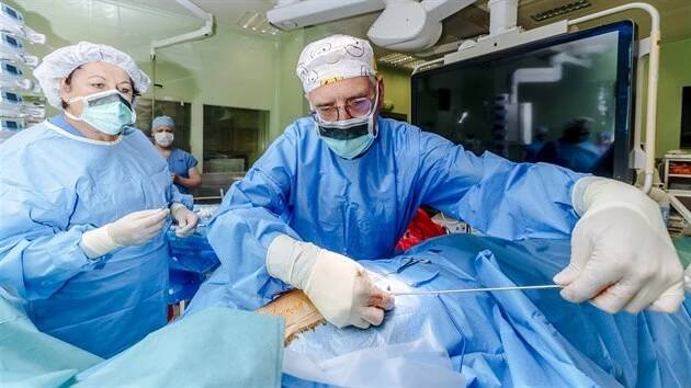 Kardiologické oddělení Nemocnice na Homolce se vrací k výkonům, které muselo kvůli opatřením v souvislosti s COVID-19 omezit. Tým pod vedením kardiologa Petra Neužila (na snímku v brýlích a smajlíkové čepici) provedl implantaci subkutálního implantabilního defibrilátoru. Kardiologické centrum na Homolce pracuje na řadě mezinárodních výzkumných studií. K nim patří i výkon tzv. katetrizační ablace fibrilace srdečních síní. (+5. května 2020)