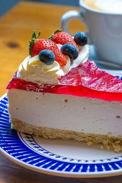 Free A scrumptious slice of cheesecake topped with fresh strawberries and blueberries, ideal dessert. Stock Photo