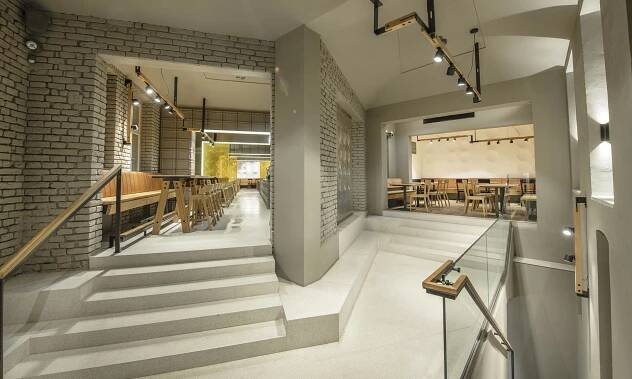 Na pražském Žižkově vyrostla restaurace Sou100 z šedých přepravek a zlatavého skla – DesignMag.cz