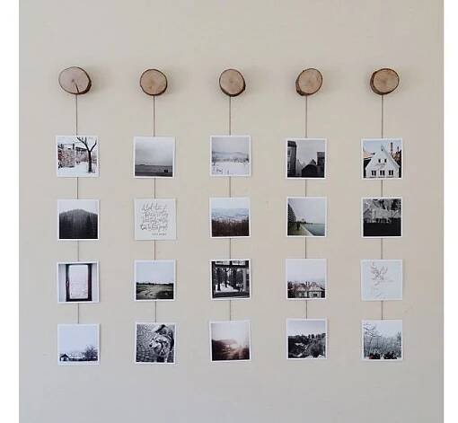a wall with several pictures hanging on it's sides and some clocks attached to them