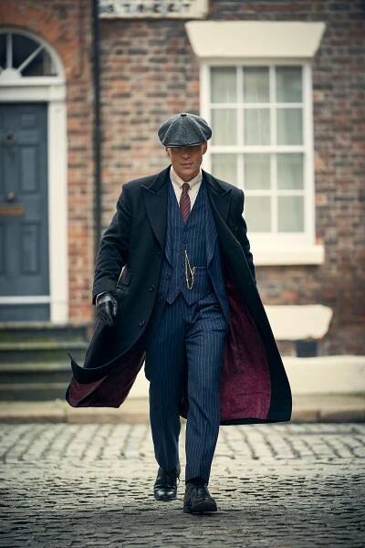 Tommy Shelby walks forward, his dress coat blowing in the breeze in 'Peaky Blinders'