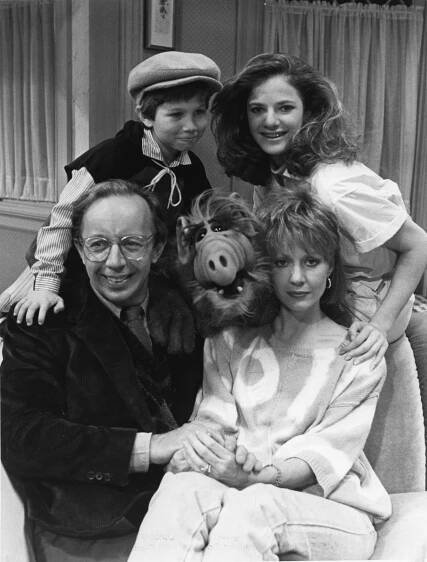 Cast of 'ALF' including Max Wright, Benji Gregory, Andrea Elson, and Anne Shedeen posing for a photo with the Alien Life Form puppet in 1986
