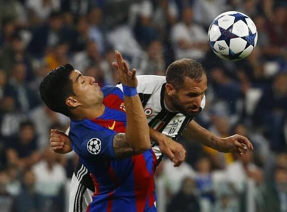 Barcelona's Luis Suarez in action with Juventus' Giorgio Chiellini