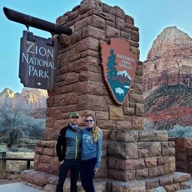 Andrew and Ashley, co-founders of Mindful Roamers, at the entrance of Zion National Park