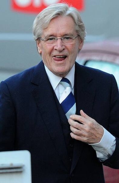 a man wearing glasses and a blue and white striped tie